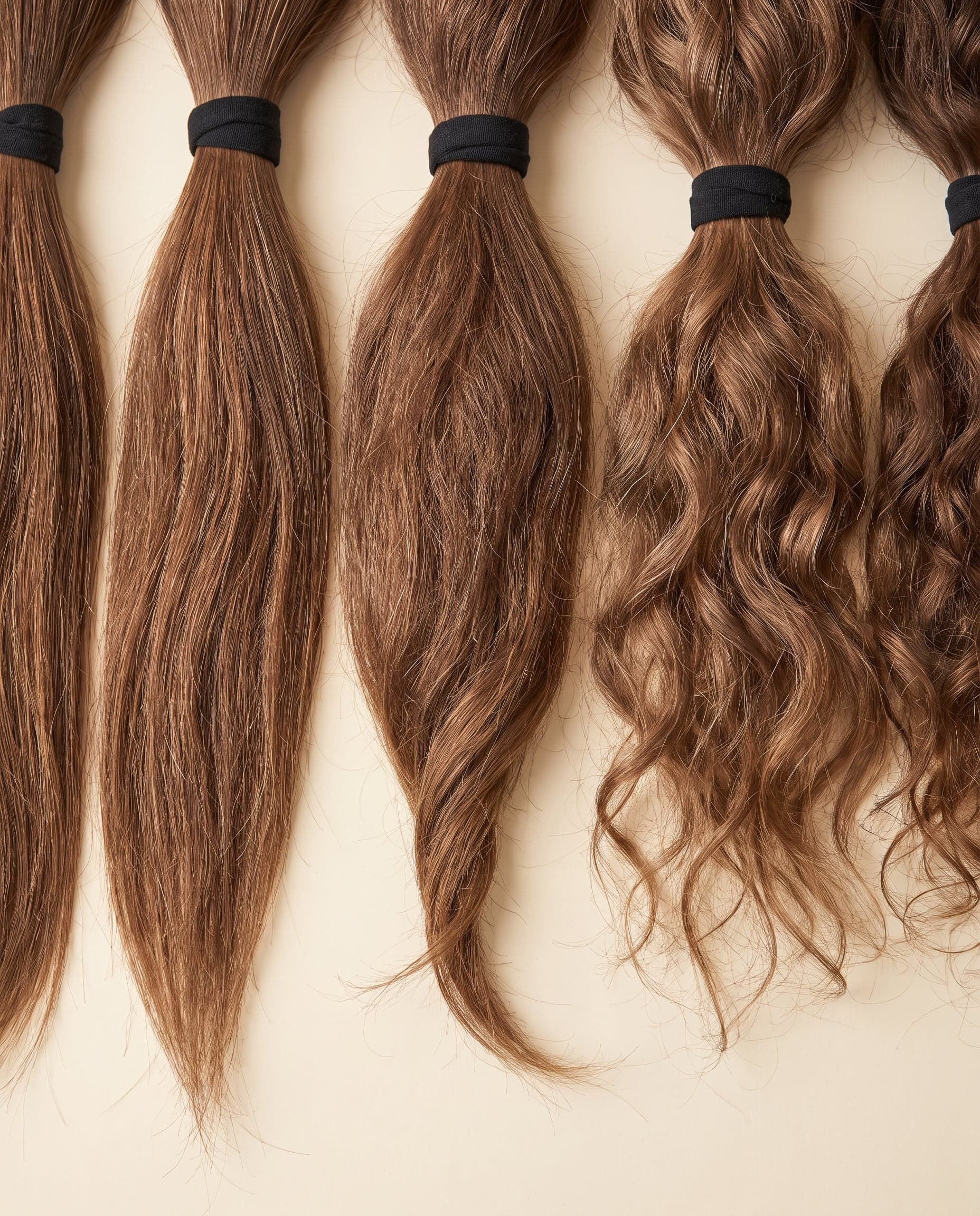 Gold grade bundles in natural light brown spread from straight to curly textures