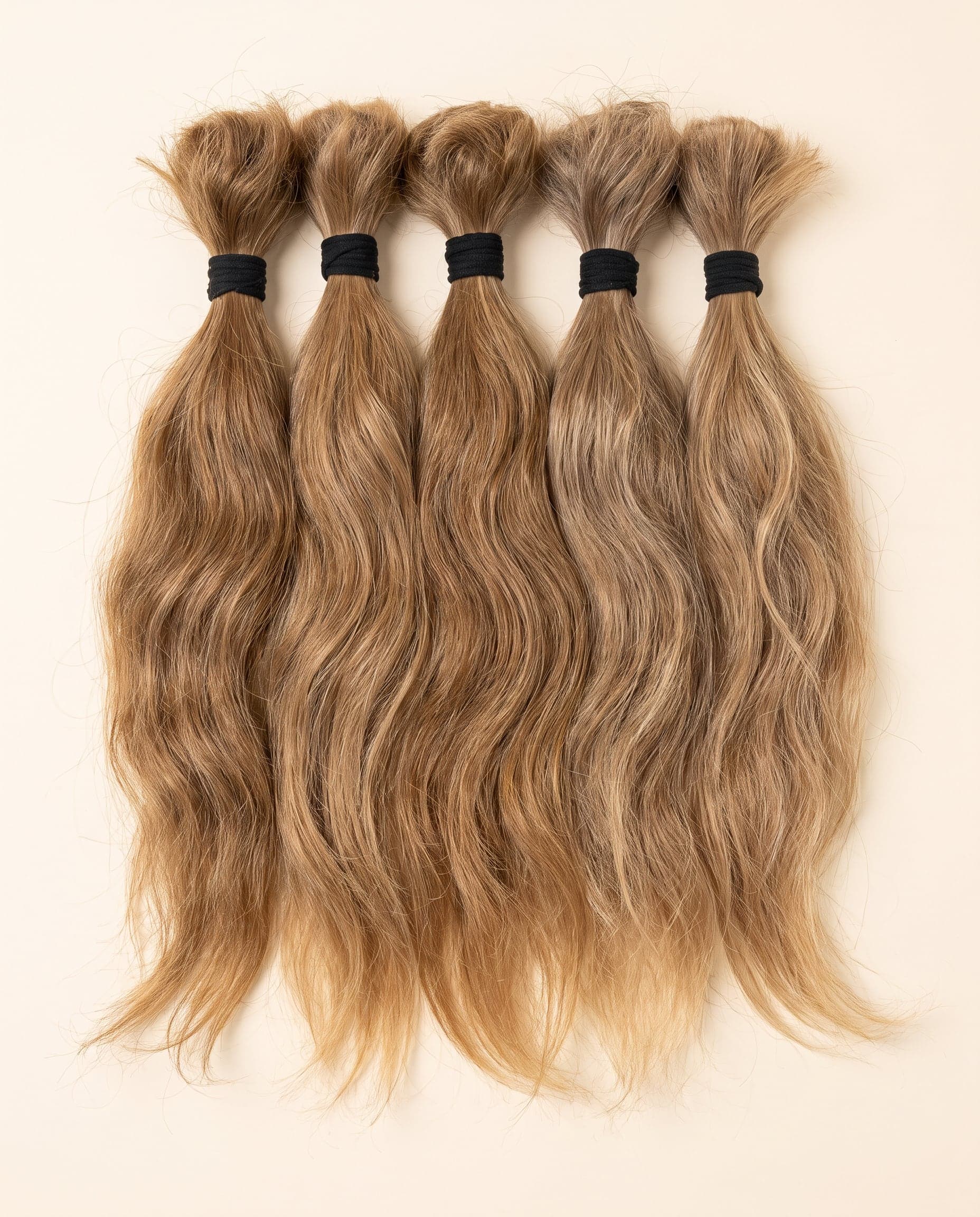 Premium grade single-donor hair bundles in natural blonde and light brown shades in a row
