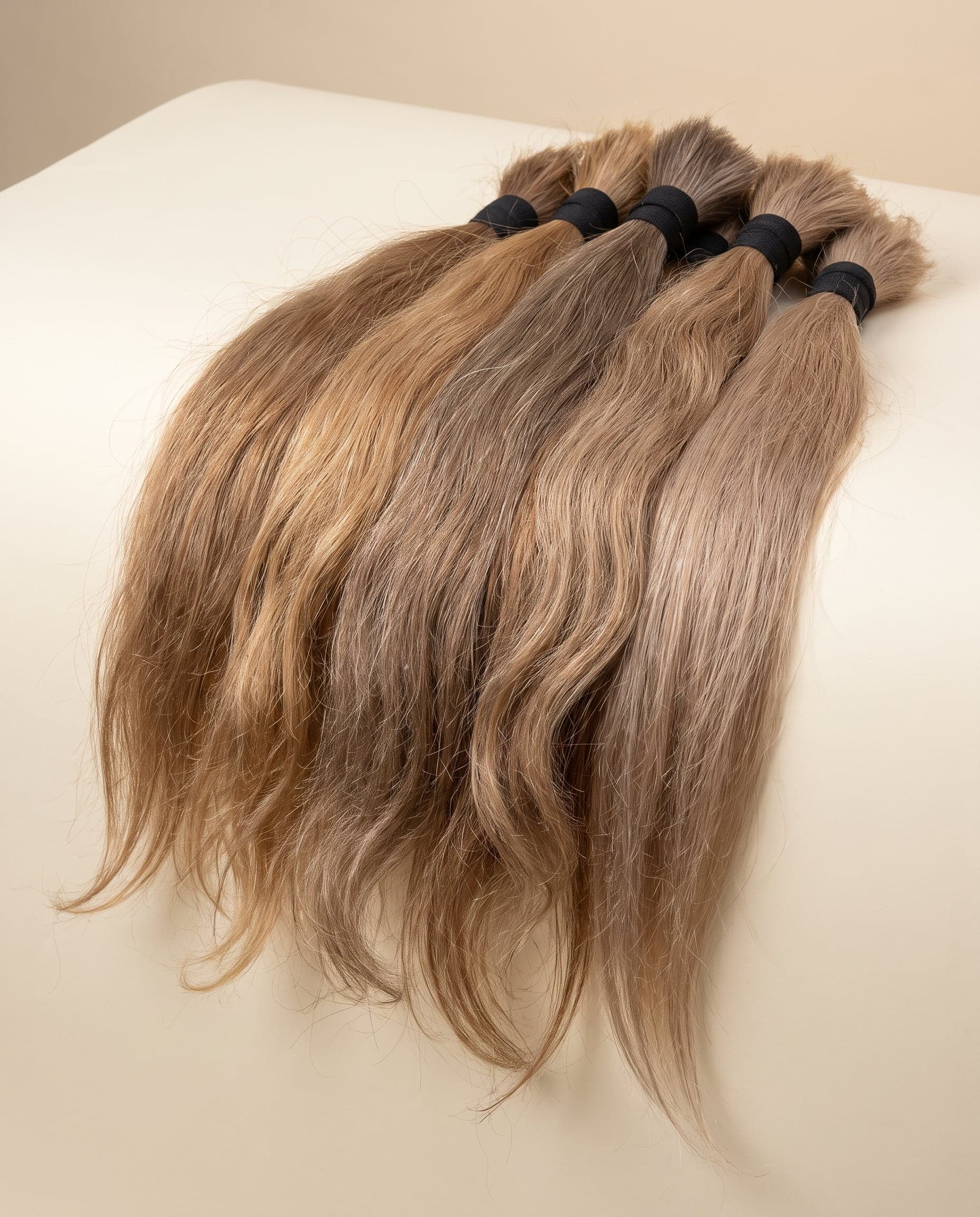 Fan of Premium grade bundles from light brown to blonde with straight, wavy, and curly textures