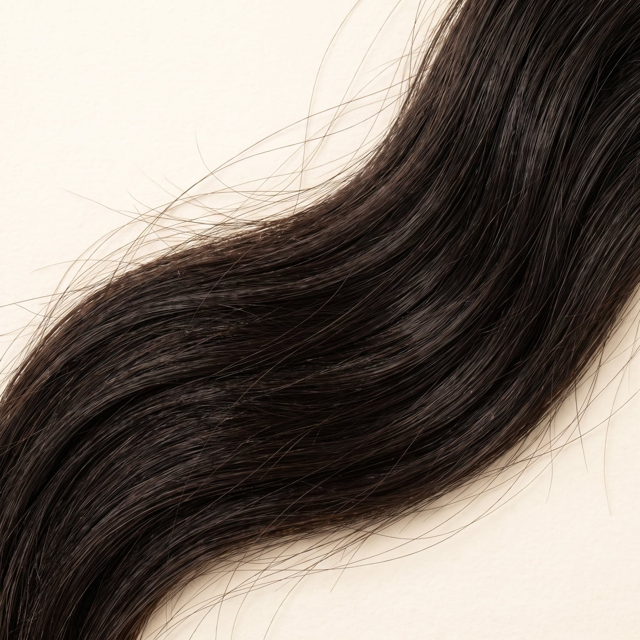 Close-up of Silver grade hair strands showing soft dark natural color, healthy shine, and strand detail
