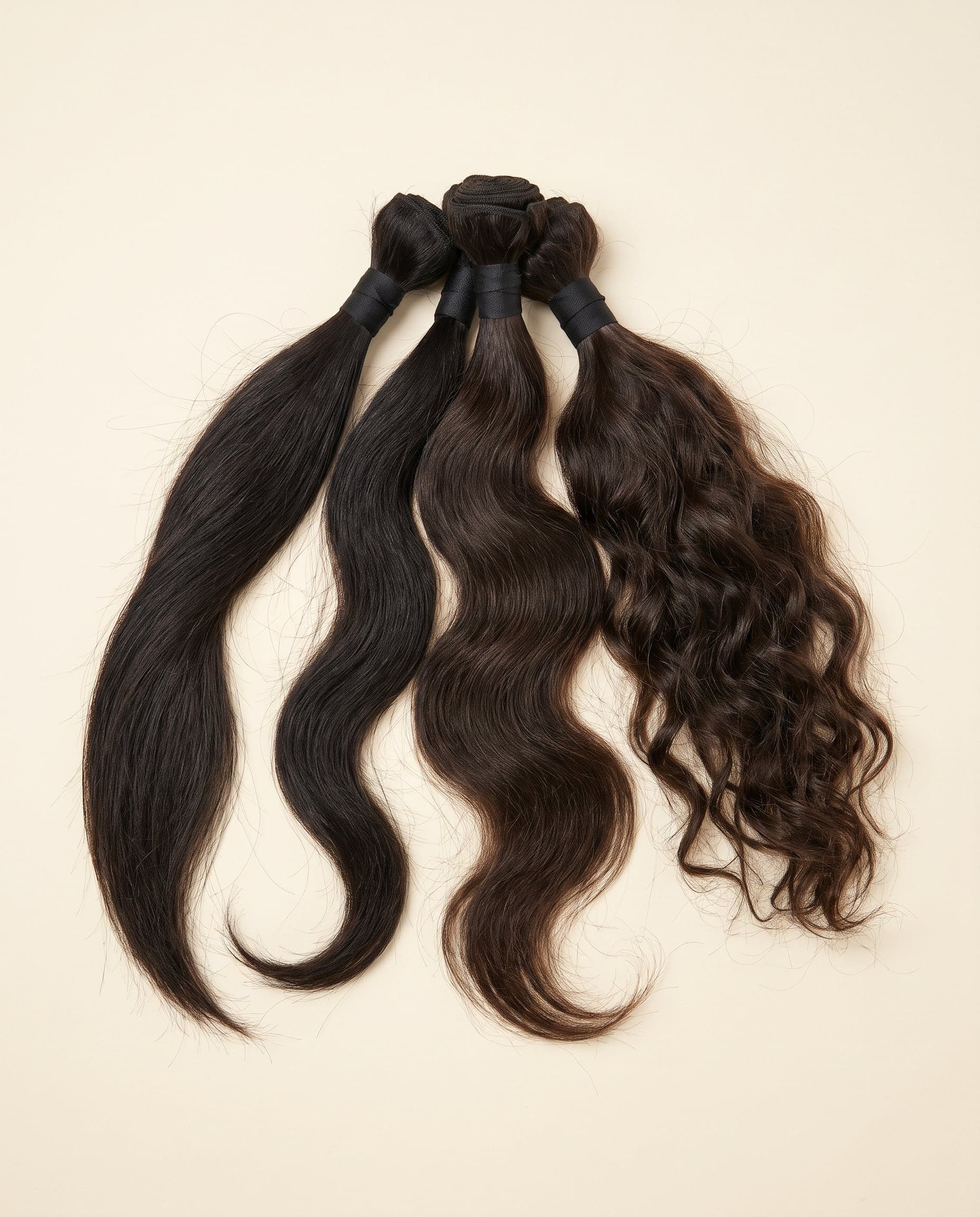 Fan of Silver grade bundles showing wavy, straight, and curly darker natural textures
